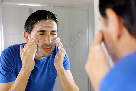 洗脸时用面部净化器洗脸的人在家里的浴室里洗肥皂图片