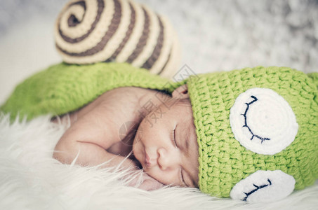 特写镜头可爱的新生婴儿与服装睡觉新生图片