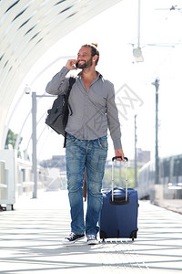 随手机和行李走的旅游男子图片