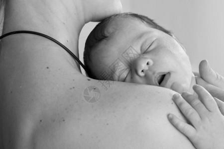 妈抱着睡的婴儿在白色的照片图片