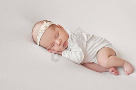 可爱的新生女婴躺在白色的毯子里婴儿用品包装模板新生婴儿的特写肖像图片