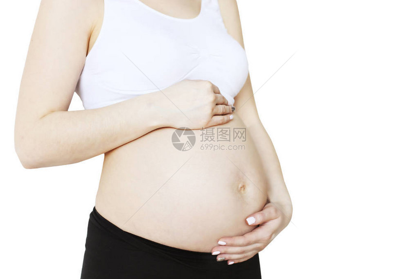 孕妇身穿支撑无缝孕妇胸罩和黑色瑜伽裤图片