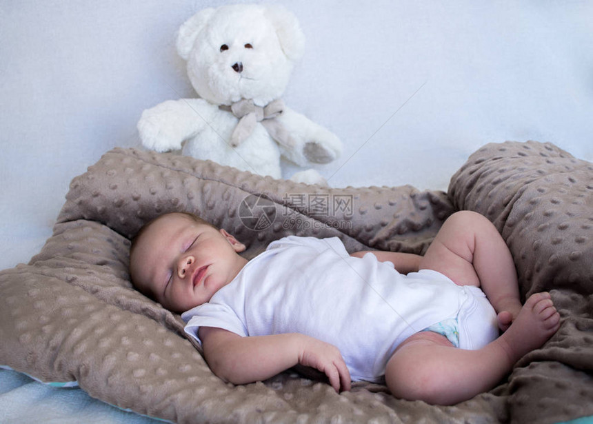新生儿婴在背景中与白泰迪熊图片