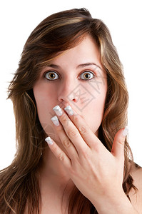 震惊的女人用手遮住她的嘴唇在白色背景图片
