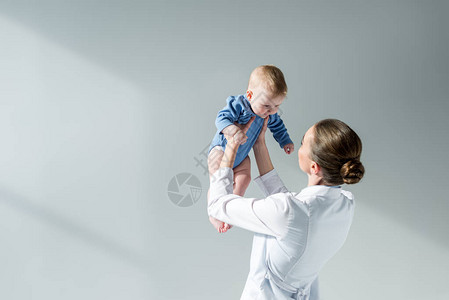 女儿科医生与灰色小婴儿玩图片