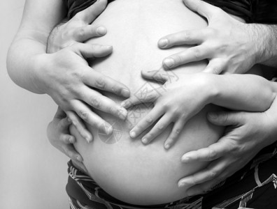 父亲母亲和孩子的手放在怀孕肚子图片