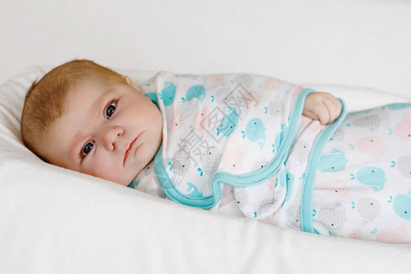 可爱的新生婴儿裹着五颜六色的毯子图片