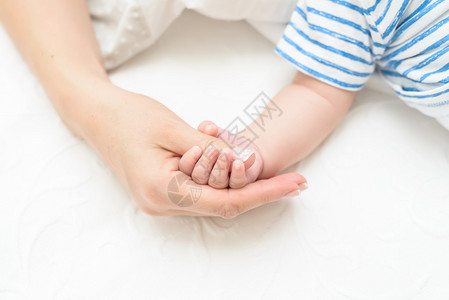 抚养新生儿的母亲的母手图片