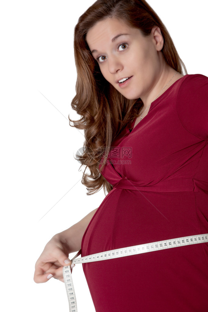 迷人的年轻孕妇期待双胞胎用卷尺测量她突出的腹部图片