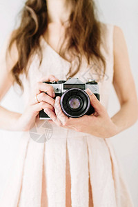 拿着旧胶卷相机的年轻女人背景图片