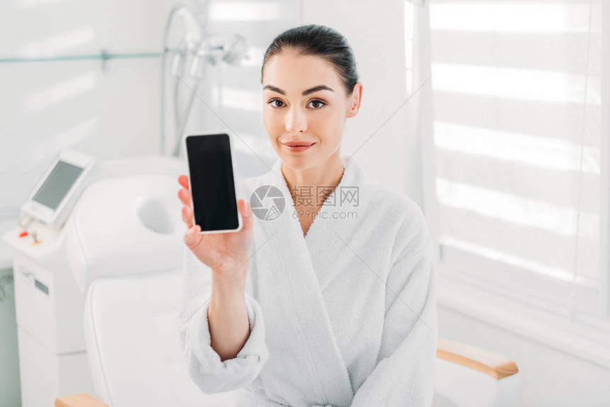 白色浴袍中的女子在温泉沙龙用空白屏幕图片