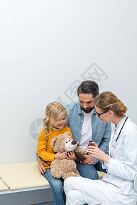 年轻医生给小女孩的泰迪熊糖浆图片