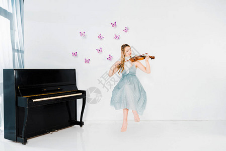穿蓝裙子的漂浮女孩在白色背景与紫蝴蝶和复制图片