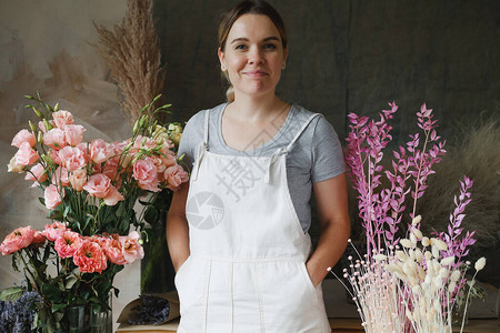 围裙站在花背景上的女人创业花商工匠工艺服务厨师小企业图片