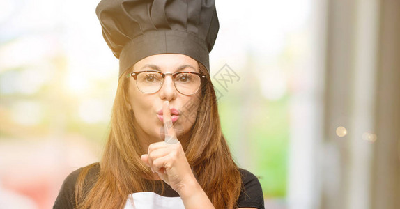 中年厨艺女厨师穿着大厨围裙嘴唇用食指图片
