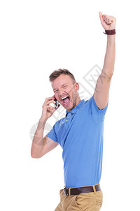 照片中一位青年临时男子在电话上欢呼时举起拳头向空中挥舞图片