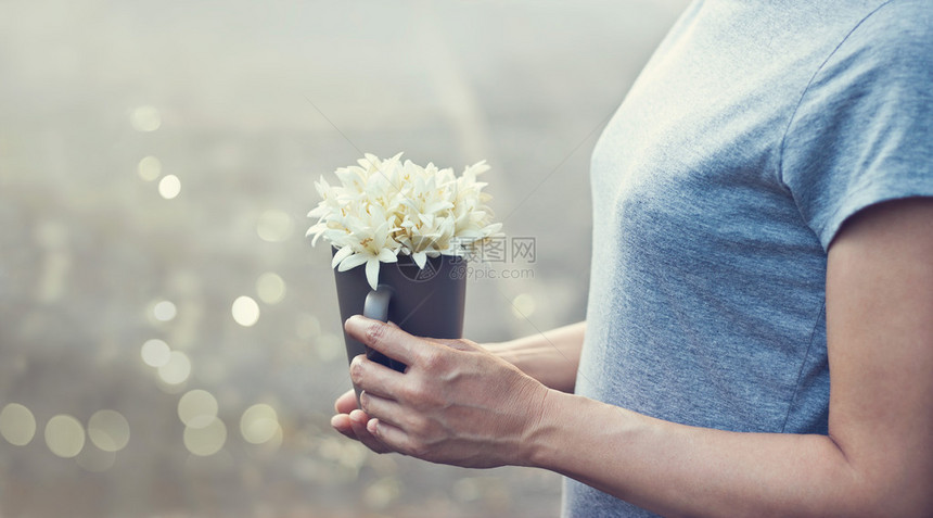 带着白色花束的女祷告者手握着白色花束图片