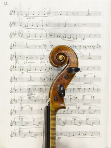 背景乐谱上美丽的小提琴乐器弦图片