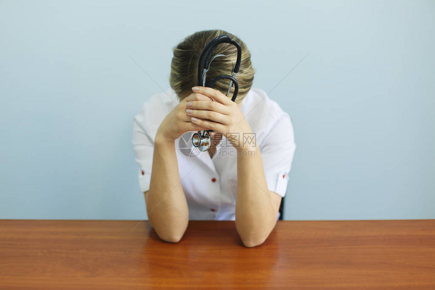 哭不开心的护士坐在办公桌前的医生因压力崩溃而感到悲伤和沮丧医疗保图片