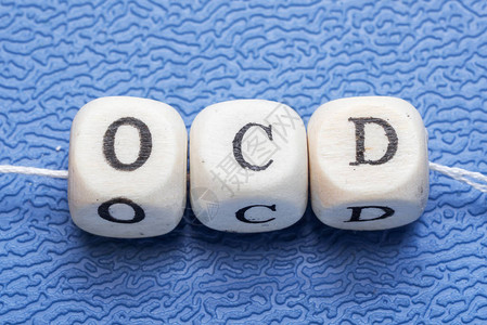 蓝色背景的木立方体上的单词ocd强迫图片