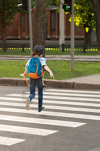 背着包的小学生沿着人行道穿过马路图片