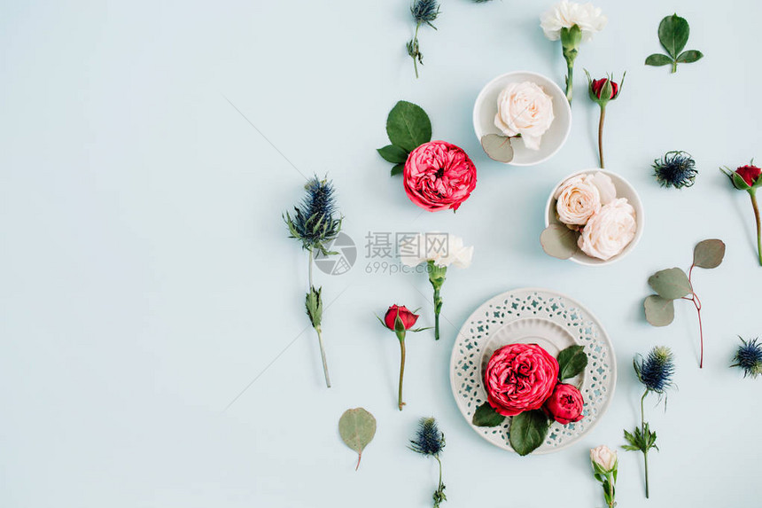 花朵由盘子上的红玫瑰和蜜蜂玫瑰白康乃馨和叶卡利普图斯树枝组成图片