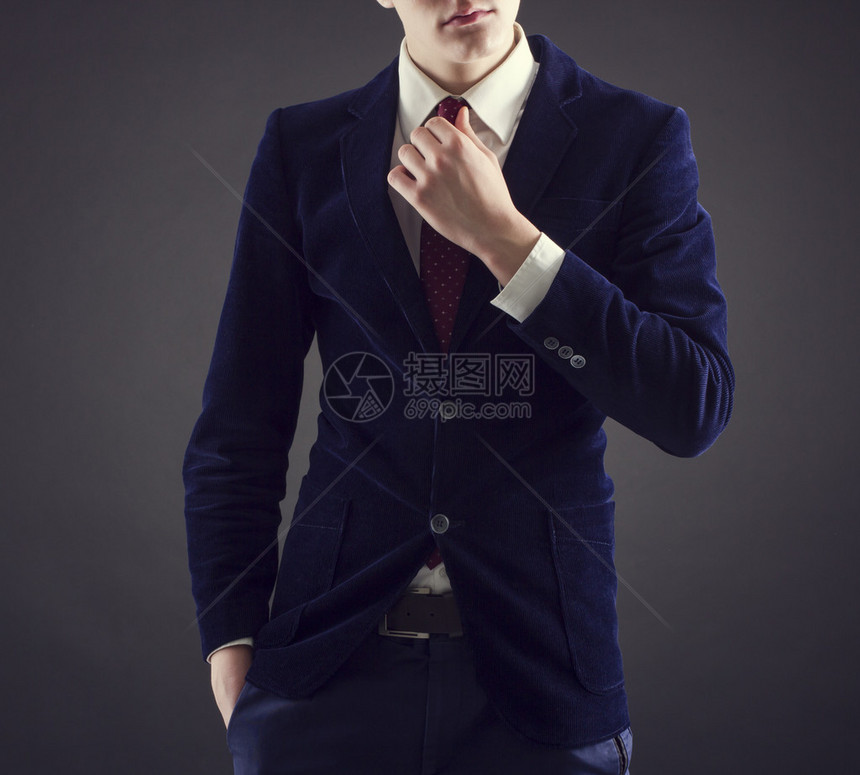 穿蓝西装的年轻时尚男子深底红图片