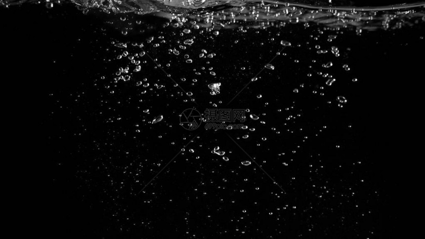 漂浮在黑色背景上的水泡代表苏打水或碳酸饮料的提神效果图片