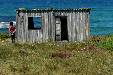 女人和海岸的老房子图片