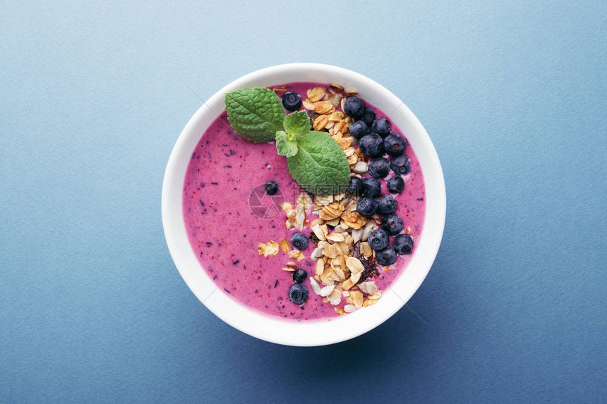 蓝莓和薄荷糖的滑盘碗蓝色背景健康早图片
