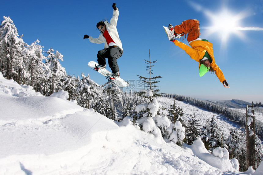 跳跃反对蓝天的滑雪板运动员图片