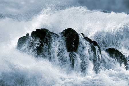 巨浪冲撞巨石的详细照片图片