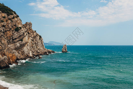 看到海和蓝天空左边的岩石强风和波图片