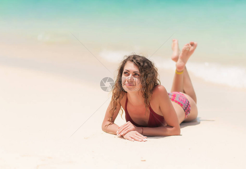 年轻女子在海边的沙子上微笑图片