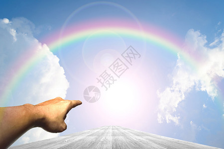 手在木方式和蓝天背景与彩虹图片