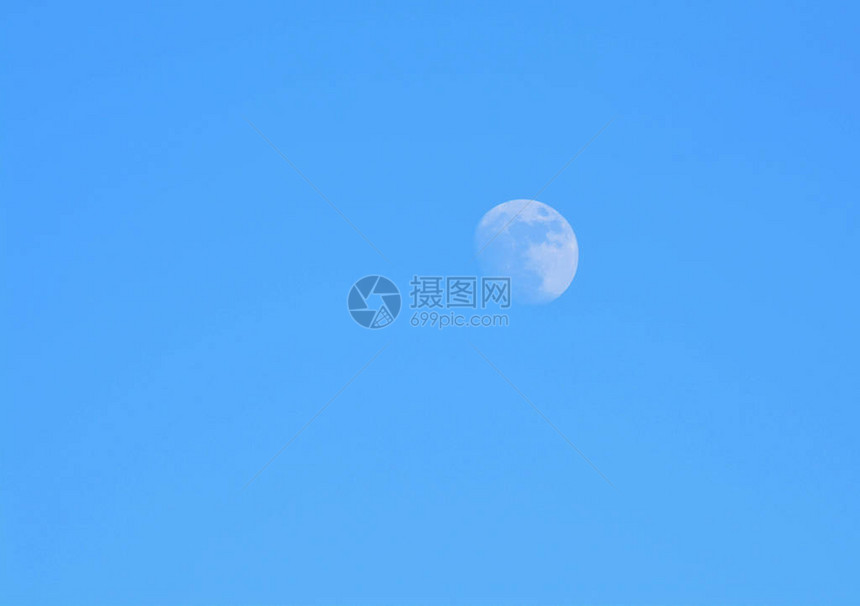 白天几乎是满月在湛蓝的天空中图片
