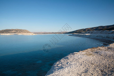 美丽的平静湖岸上的白石灰沙尔高清图片