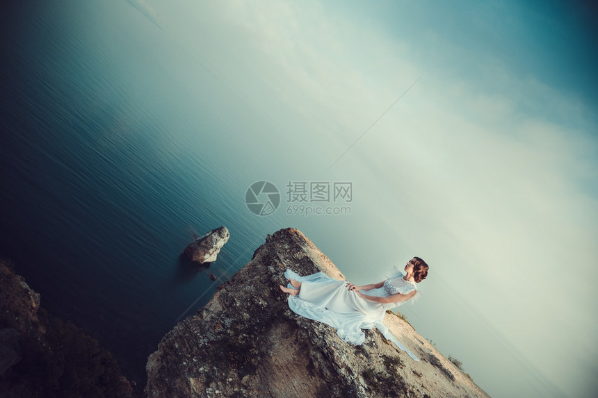 美丽的新娘在海岸上摆着天使般的装束图片