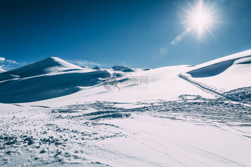 阳光明媚的寒雪覆盖着美丽的冬季山脉图片