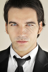 一个穿着正式黑西装带着明蓝双眼领带的帅男模特详图片