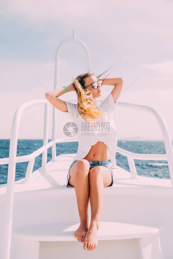 游艇上迷人可爱的棕色美女在度假时享受阳图片