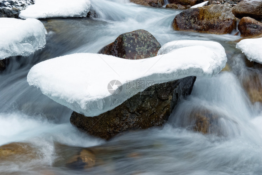 冰和水流中的石头图片