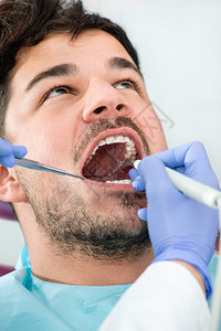 牙菌斑去除剂男病人在牙医办公室被拆除背景