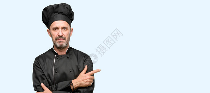 高级厨师身戴大厨帽手指向另一边手指图片