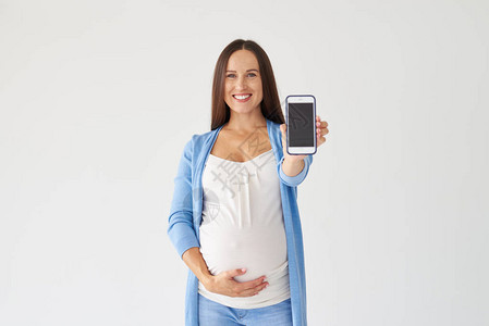 孕妇显示手机背景隔离的特写镜头图片