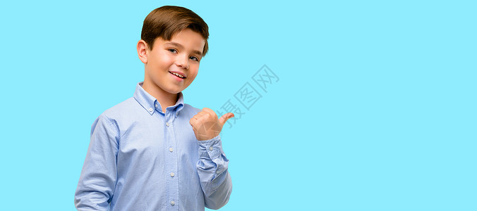 青绿眼睛的成熟幼童用手指对着蓝色背图片