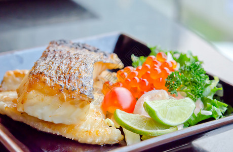 日式烤鳕鱼和新鲜沙拉配鱼蛋背景图片
