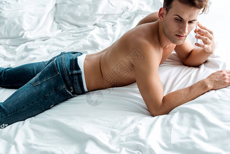 穿着牛仔裤的帅男子在睡房时用背景图片