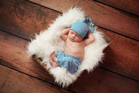 新生婴儿睡在人造毛皮上的木箱里图片