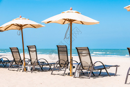 蓝色天空热带海滩上的沙滩椅和遮阳伞图片
